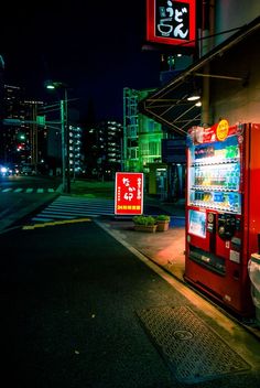 a vending machine sitting on the side of a road next to a street sign