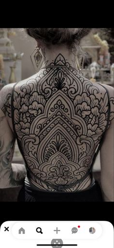 the back of a woman's body with tattoos on it