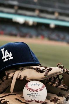 a baseball mitt with a cap on top of it and a ball in the glove