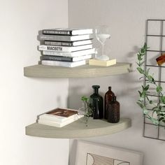 two shelves with books and vases on them next to a wall mounted planter