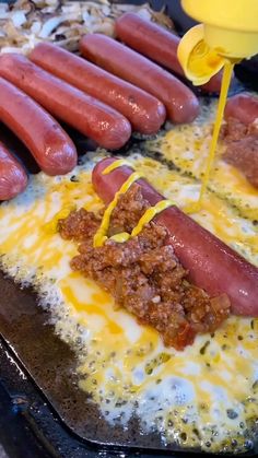 hot dogs are being drizzled with mustard