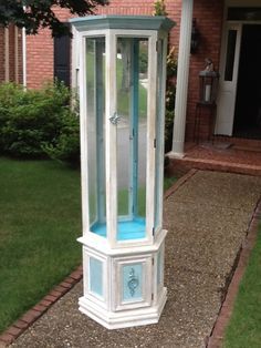 a white and blue grandfather clock in front of a house