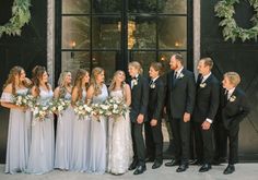 a group of people standing next to each other in front of a building with wreaths