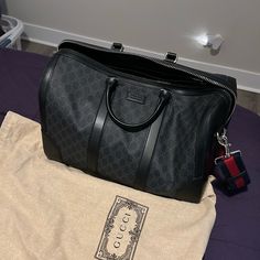 Never Used But No Tags. Comes With Gucci Cloth. Gucci Men Clothes, Designer Top Handle Duffle Bag For Shopping, Designer Top Handle Duffle Bag With Dust Bag, Designer Duffle Bag For Shopping, Designer Black Rectangular Travel Bag, Designer Everyday Duffle Bag, Designer Duffle Bag For Everyday Use, Designer Black Travel Bag With Top Carry Handle, Designer Travel Bag With Top Carry Handle