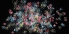 fireworks are lit up in the night sky with many colors and shapes on it's black background