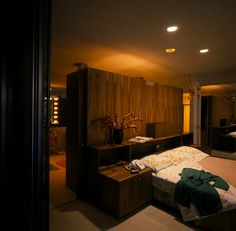 a bedroom with a bed, dresser and mirror on the wall next to each other