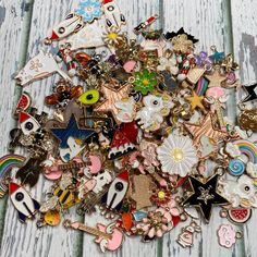 a pile of assorted pins and badges sitting on top of a wooden table