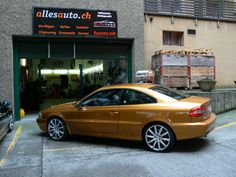 a gold car parked in front of a building