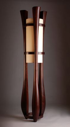 a tall wooden floor lamp with two lamps on each side and one light in the middle