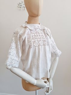 This Romanian blouse features geometrical cut-out embroidery and an adorable Peter Pan collar with white floral embroidery. The sleeves have the same geometrical cut out embroidery that is featured on the front of the blouse as well, that are a fine example of handwork.  MATERIAL: Linen CONDITION: Really good vintage condition.  Measurements: (taken flat / lying down) Total length:  55 cm Bust size (underarm to underarm): 45 cm Armhole: 20 cm Waist: 48 cm Shoulder width: 39 cm Sleeve length: 26 Luxury Embroidered Linen Blouse, Luxury Linen Embroidered Blouse, White Embroidered Top With Collar, Elegant Summer Tops With Geometric Embroidery, Summer Cutwork Cotton Blouse, Summer Cotton Cutwork Blouse, Summer Cotton Blouse With Cutwork, White Doll Collar Top With Floral Embroidery, White Collared Blouse With Floral Embroidery