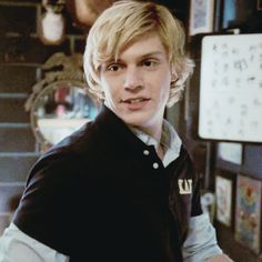 a young man with blonde hair wearing a vest