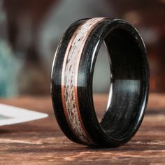 a wooden ring with antler and black ceramic inlay