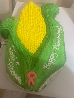 a cake with green frosting and yellow flowers on it's side that says, happy birthday