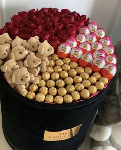 a large black hat box filled with chocolates and teddy bears next to a stuffed bear