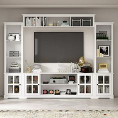 a white entertainment center with bookshelves and a flat screen tv mounted on the wall