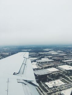 the wing of an airplane flying over a city