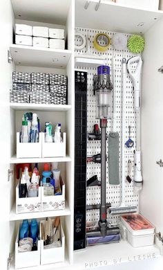 an organized craft room with pegboard walls and white shelving unit filled with supplies