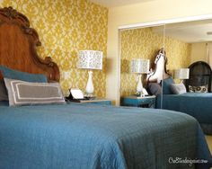 two beds in a room with yellow and blue wallpaper on the walls next to each other