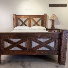 a bed made out of wood with white sheets and pillows