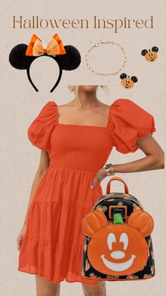 a woman in an orange dress holding a handbag and mickey mouse ears on her head