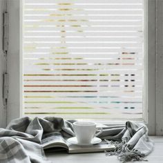 a cup and saucer sitting on top of a table next to a window