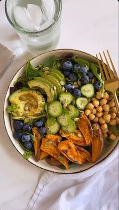 a salad with blueberries, avocado, cucumbers and chickpeas