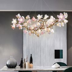 a chandelier with flowers hanging from it's ceiling in a dining room