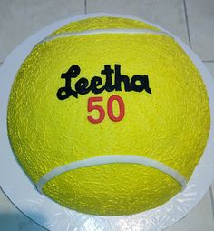 a yellow tennis ball cake with the number 50 on it's front and side