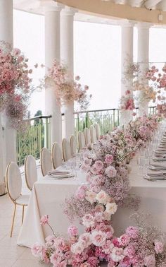 the table is set with white and pink flowers