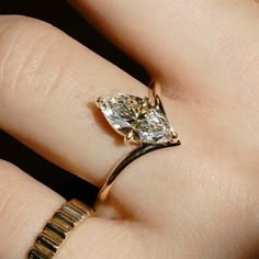 a woman's hand with a ring on it and a diamond in the middle