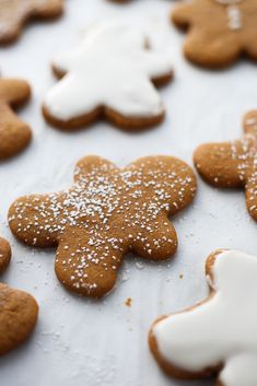 gingerbread cookies with icing and powdered sugar are arranged on a baking sheet