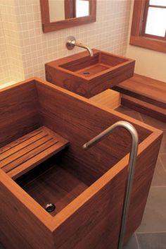 two wooden sinks in a bathroom with tiled walls and flooring, one is made out of wood