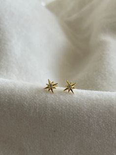 * Metal Material: S999 with 18K Gold Plated - S925 Backing * Stone: Zircon  * Dimensions: 6.34mm X 6.10mm * Color: Gold * Sold as a pair (2 pieces) The North Star means direction, guidance, stability and purpose. May these earrings inspire you to keep working on your goals no matter how much obstacles you may face. These earrings are also perfect for gifts like graduation, christening/ baptist or just for encouragement. < PACKAGING & SHIPPING > All ZeniZ orders will be beautifully packaged with our branded box and ready for gift giving! All items are carefully wrapped up inside a padded envelope to ensure safe delivery. < JEWELRY CARE > * Store separately to avoid damaging your pieces * Avoid direct contact with perfume, lotions...etc * Remove when showering, swimming and going to bed ALL Dainty Yellow Gold Star Earrings, 14k White Gold Star Earrings, Yellow Gold Star Diamond Earrings For Anniversary, Celestial Star Earrings For Anniversary, Gold Celestial Cubic Zirconia Earrings, Celestial Gold Cubic Zirconia Earrings, Celestial Yellow Gold Cubic Zirconia Earrings, 14k Gold Star-shaped White Gold Earrings, Fine Jewelry Star Earrings For Anniversary