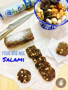 fruit and nut salami on a table next to a bowl of nuts