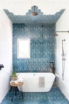 a white bath tub sitting under a bathroom mirror