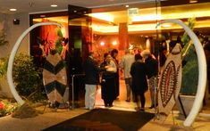 people are standing in front of the entrance to a building with art work on it