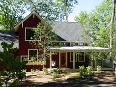 a large red house surrounded by trees and bushes in front of the house is shown