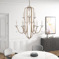 a chandelier hanging from the ceiling in a dining room with chairs around it