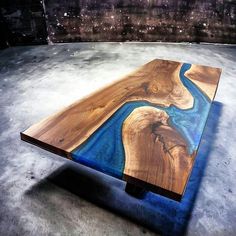 a wooden table with blue paint on it and a river running through it in the center