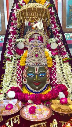 the idol is surrounded by flowers and other decorations