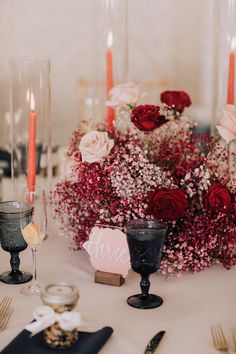 the table is set with flowers and candles