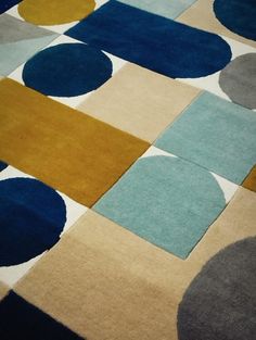 an area rug with various colored circles and squares on it's sides, including blue, yellow, gray, and white