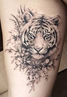 a black and white tiger with flowers on its head is shown in this tattoo design