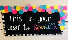 this is your year to sparkle sign with colorful balloons on the border and black background