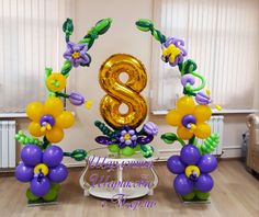 balloons and flowers are arranged around the number eight