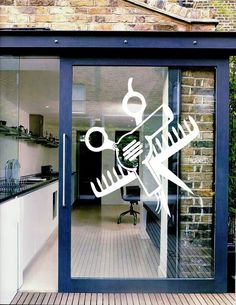 an open glass door to a kitchen with scissors and wrenches on it's side