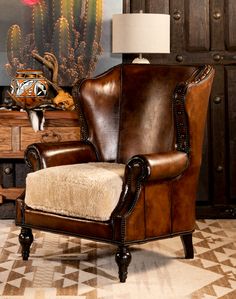 a brown leather chair sitting on top of a tiled floor next to a wooden dresser