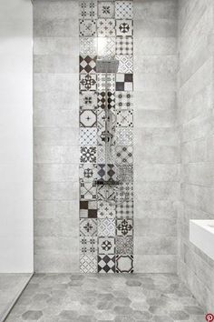 a tiled shower stall in a bathroom with white walls and floor tiles on the wall