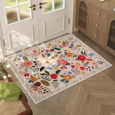 a kitchen area rug with flowers and leaves on the floor next to an open door