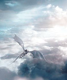 a white dragon flying through the sky above clouds